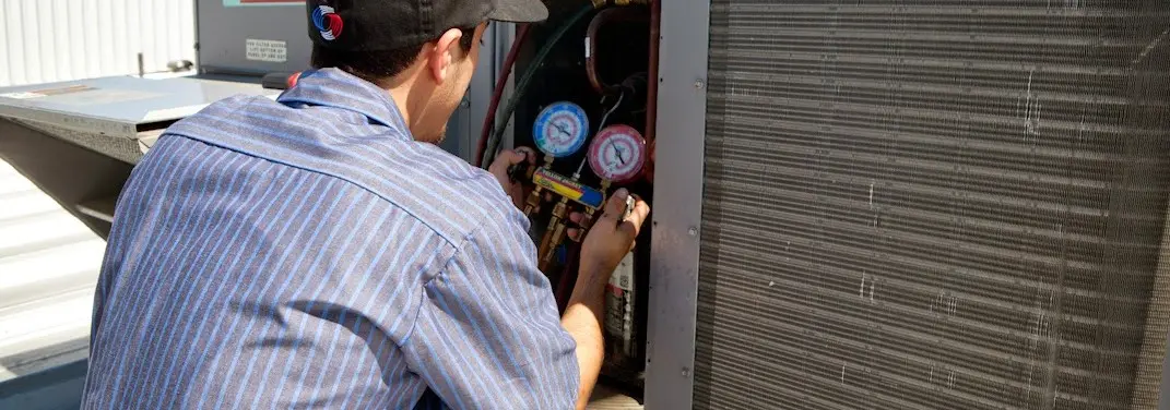 HVAC technician servicing a condenser unit in Emeryville